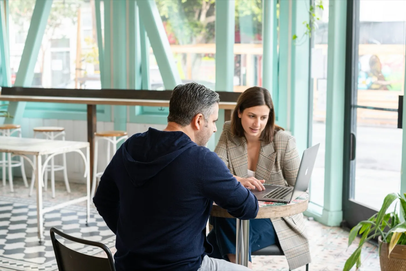 Un empresario mostrando un tour virtual a un cliente en un portátil